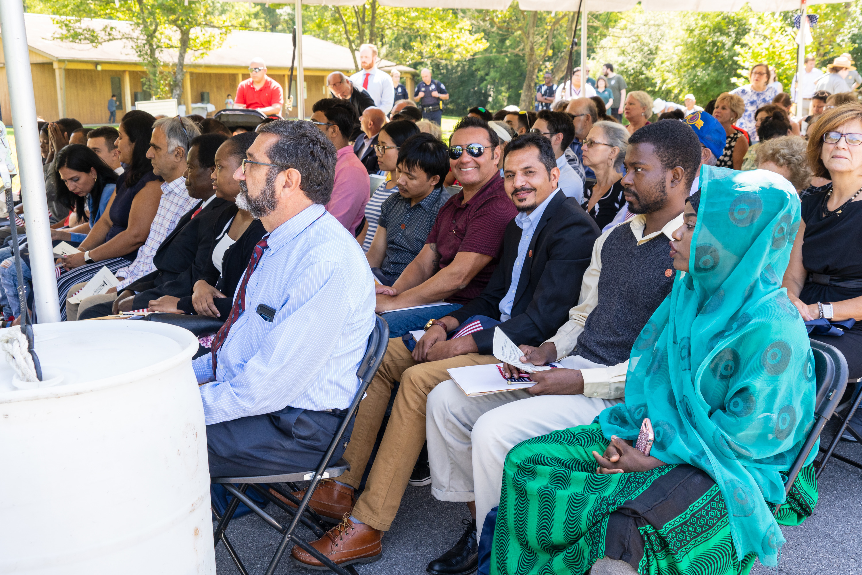 A group of people sit under a tent.