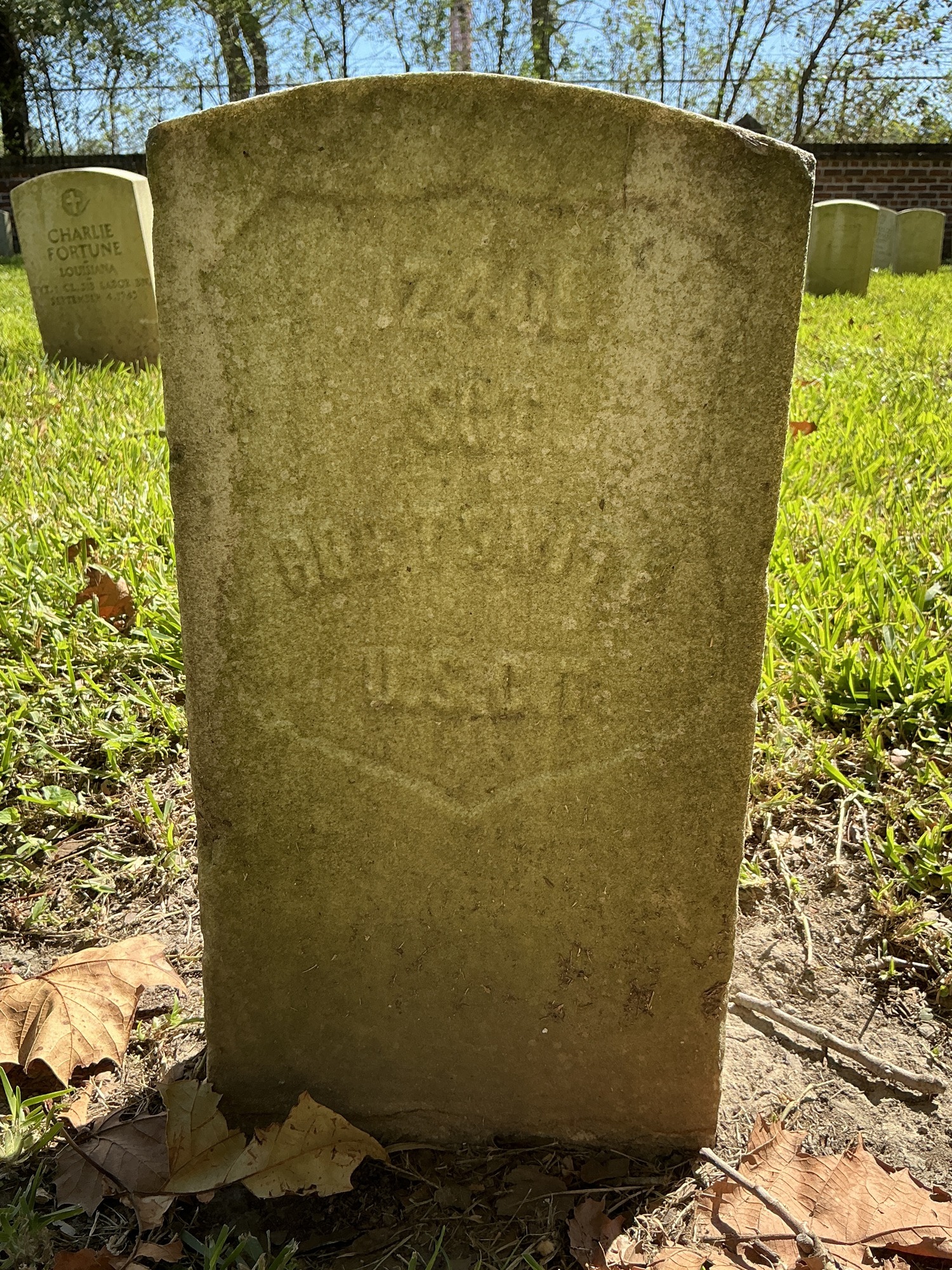 Front of historic upright marble headstone with recessed shield face.