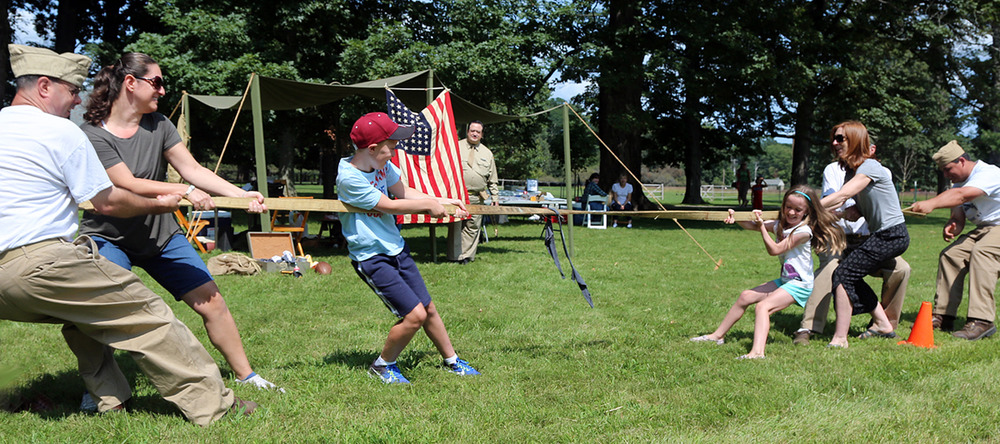 Young and older visitors play tug of war. 