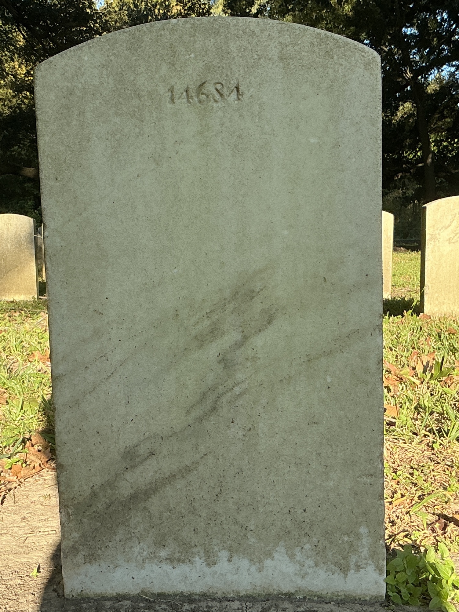 Back of upright marble headstone with flat face.