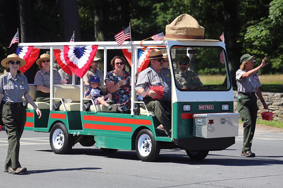 Rangers taking part of the 4th of July parade, walking and riding in a cart. 