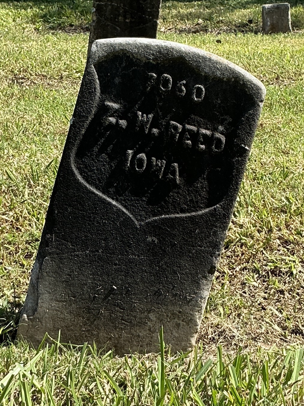 Front of historic upright marble headstone with recessed shield face.