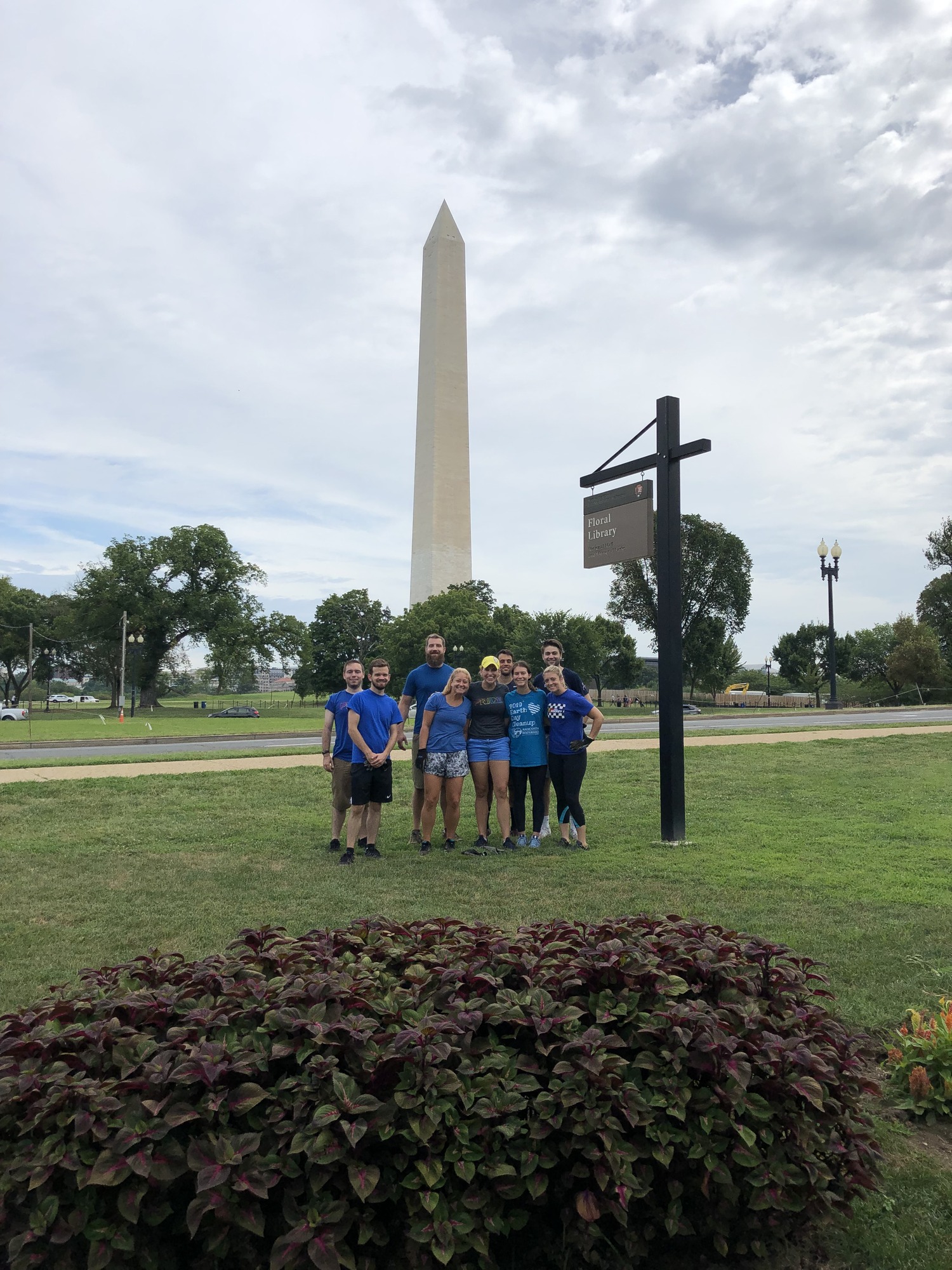 A group of individuals posing at the floral library with the Washington Monument in the background.