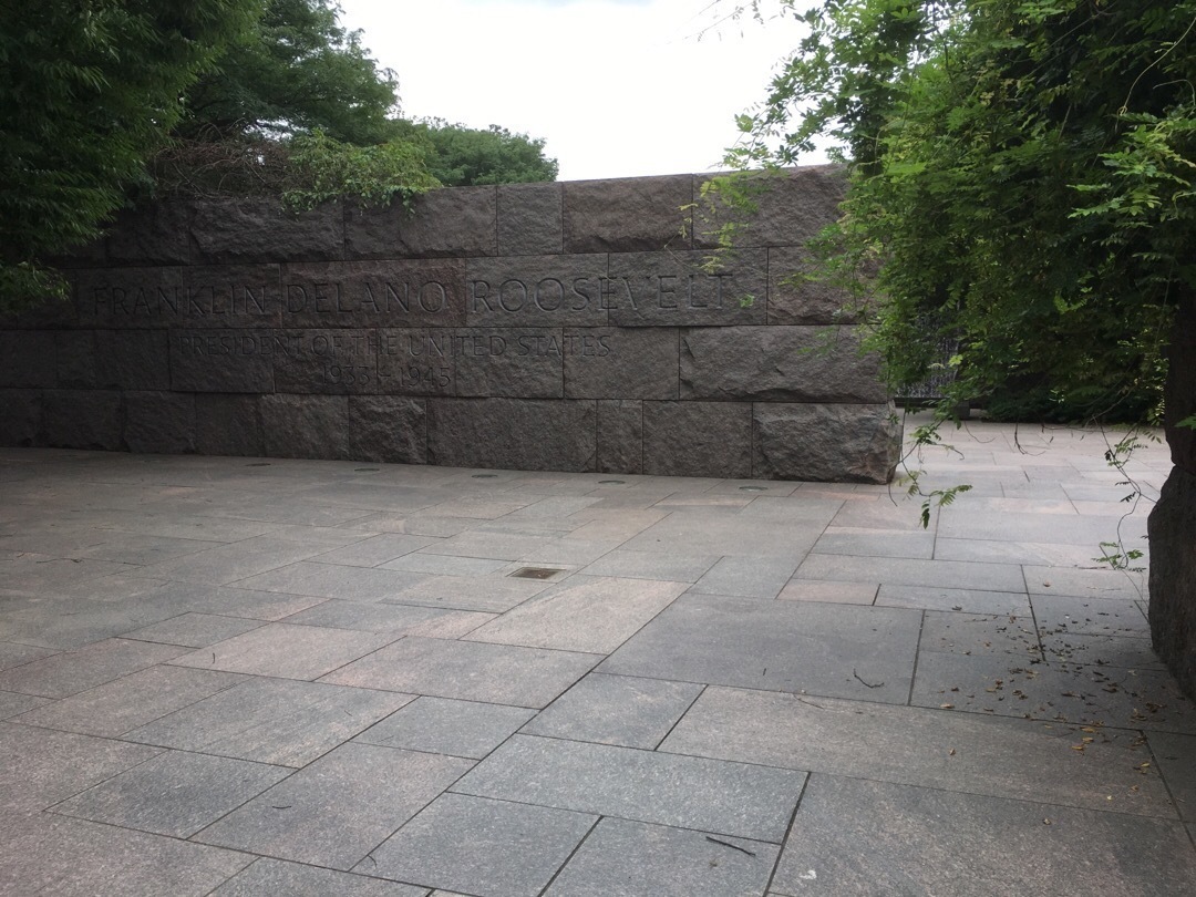 An open area with stone walls and paved with large stone slabs