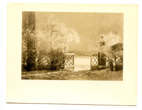 Black and white photograph of front gate covered in snow.