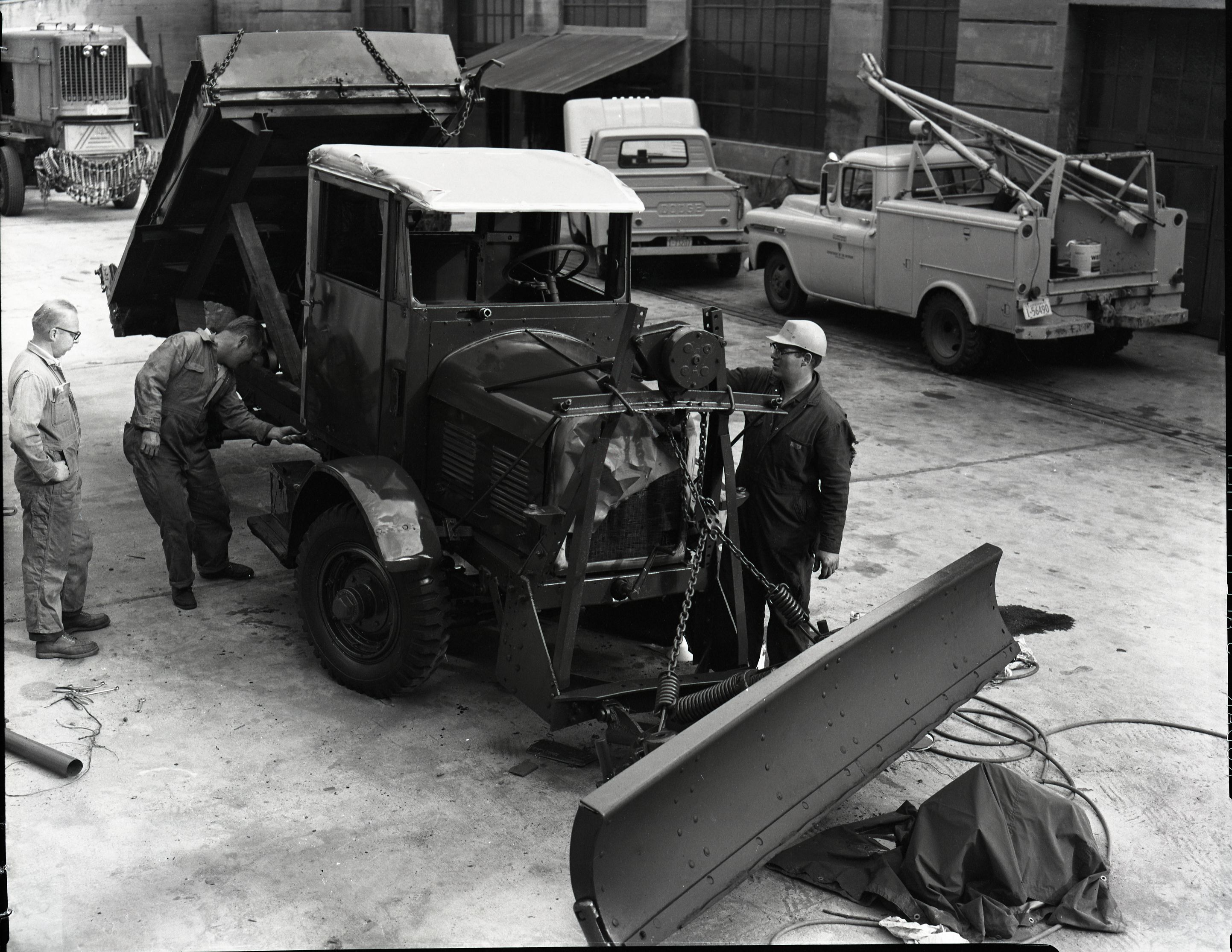 Painting FWD snow plow in maintenance area.