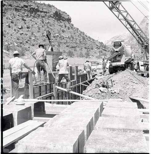 Workmen pouring cement for footing of west wall of new Mission 66 Visitor Center and Museum auditorium.