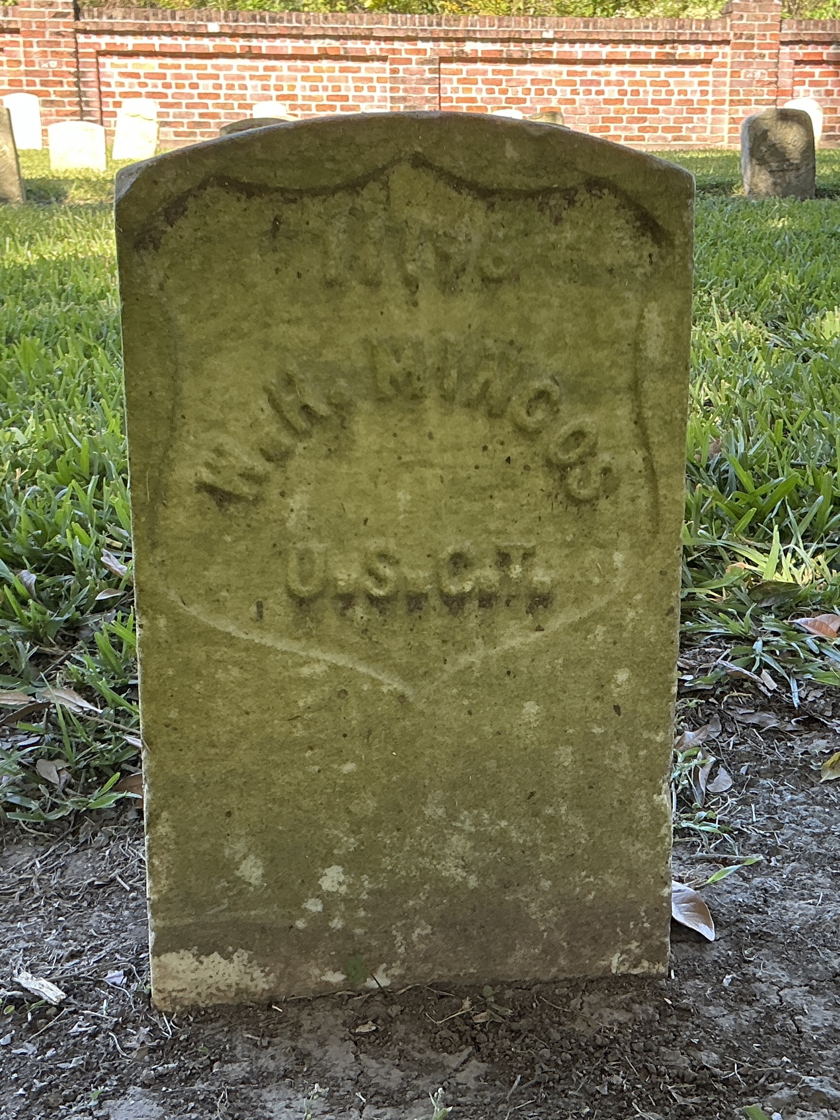 Front of historic upright marble headstone with recessed shield face.