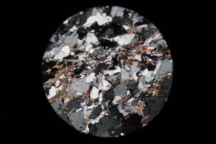 Circular microscopic image of rock structure.