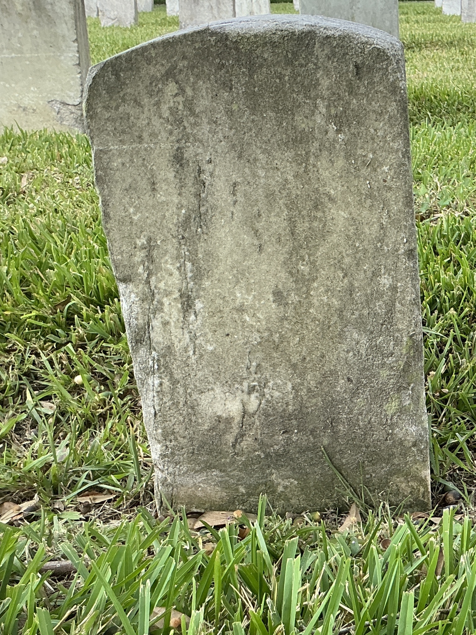 Back of historic upright marble headstone with recessed shield face.