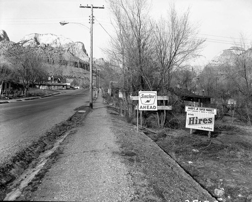 Roadside signs in Springdale, obsolete signs of Hardy Jr. Supermarket and distance to Sinclair service station.