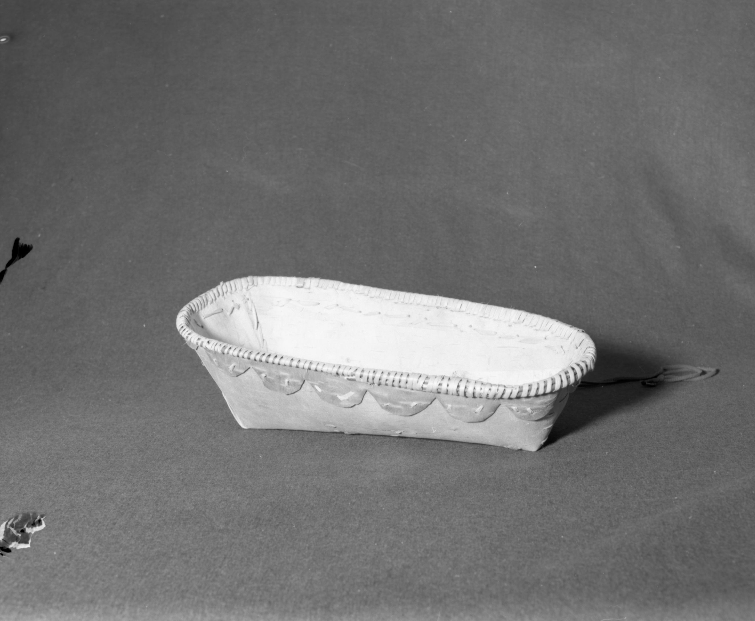 Marie Rozier Collection, Catalog No. 2-CAN-3. Object: Shushwap (Salishan) cradle basket. Dimensions: 18 x 8 1/2 x 5 1/2". Materials: Birchbark; root, unidentified shoot. Collection History: Bought at Salmon Arm, B.C., 1969. Photographed by Michael Dixon, December 1982. Catalogued by Craig Bates and Barbara Beroza. Yosemite Collections, National Park Service.