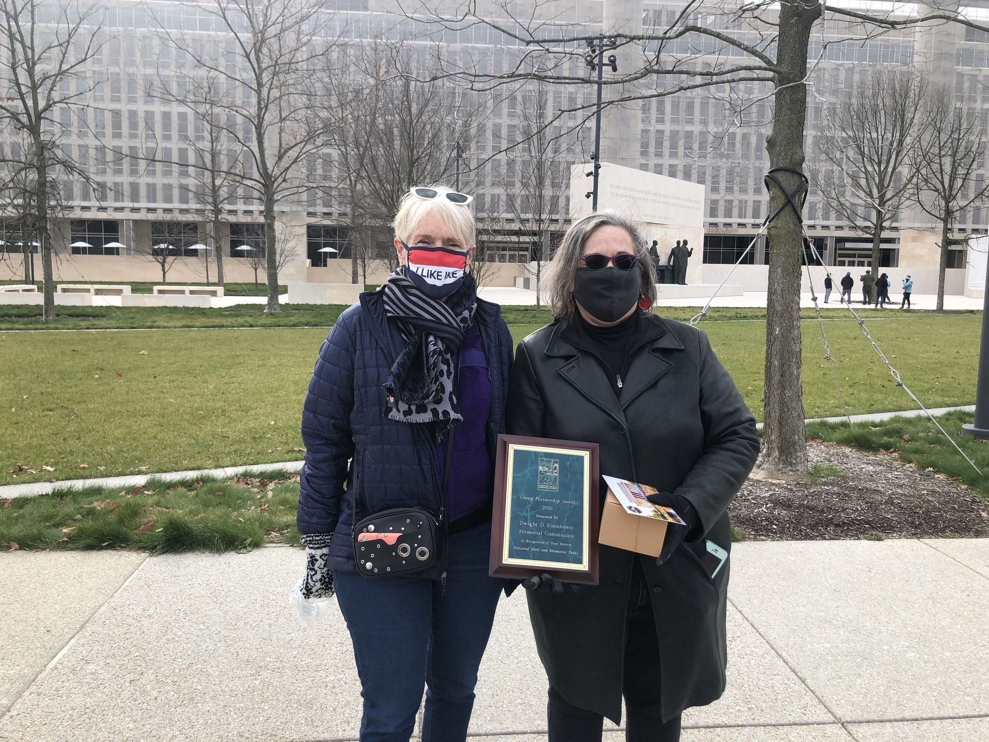 Photographed in front of the Eisenhower memorial, National Park Service staff present a representative of the  Dwight D. Eisenhower Commission with a plaque recognizing the organization as 2020 Partner of the year. 