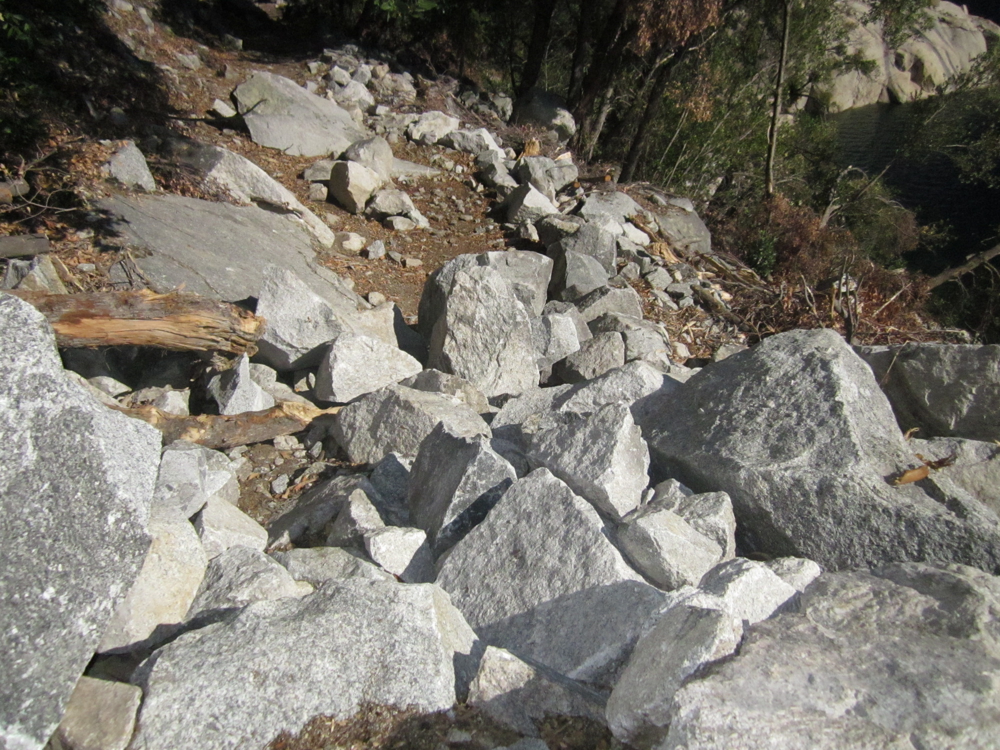 Fresh boulders covering a portion of a dirt trail.