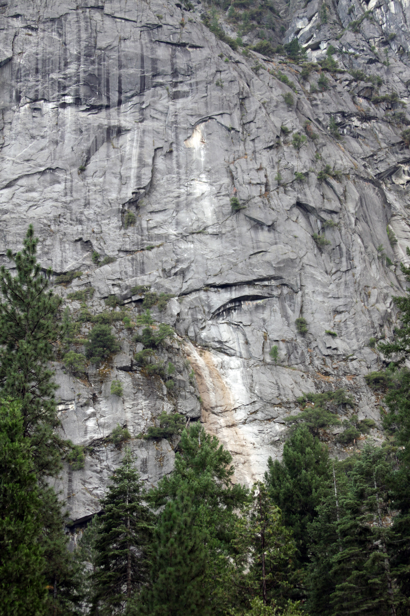 Light colored path from rock impacts extend from the rock fall source area down the rock face.