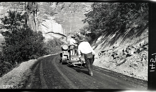 Workers rolling the new experimental pavement on the floor of the valley road.