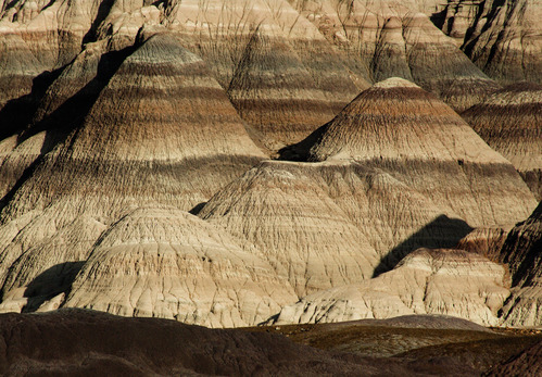 Badlands hills banded in gray, blue, purple, and brown.