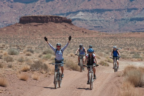 five bicyclists on an unpaved road