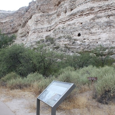 A cave above the trail with a small hill in front of it
