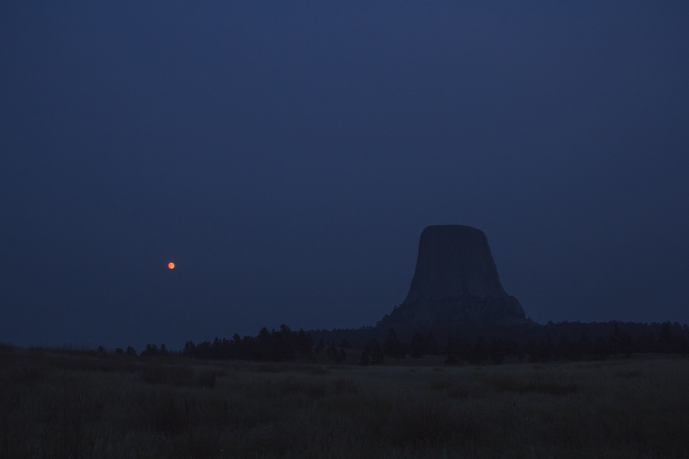 Devils Tower at night with a full moon.
