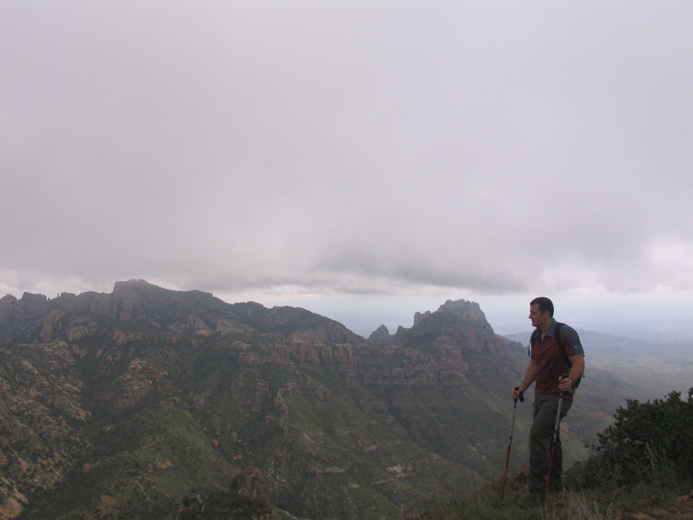 A hiker takes in the view from the Chisos Mountains on a cloudy day.