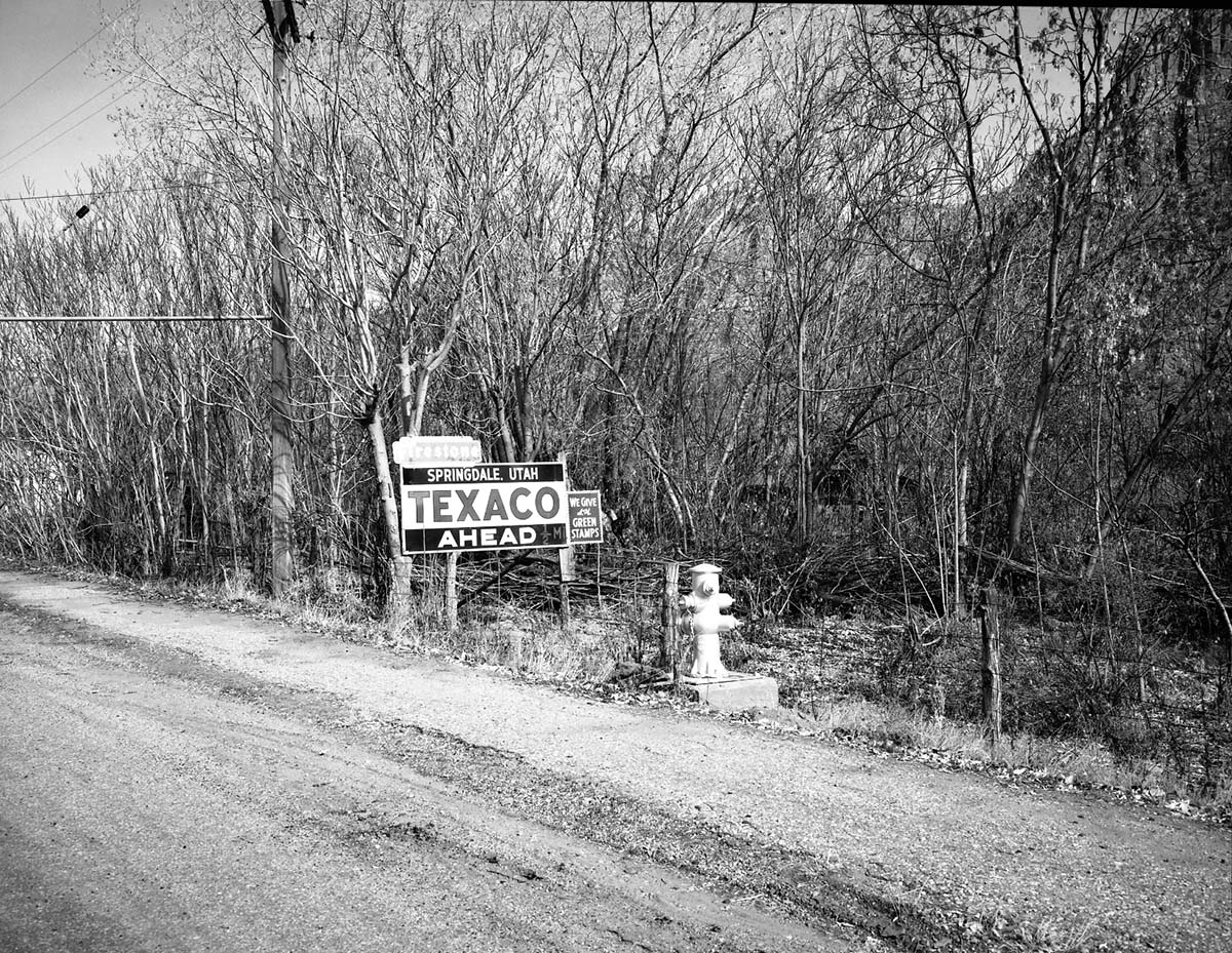 Roadside signs in Springdale. Texaco sign next to a fire hydrant.