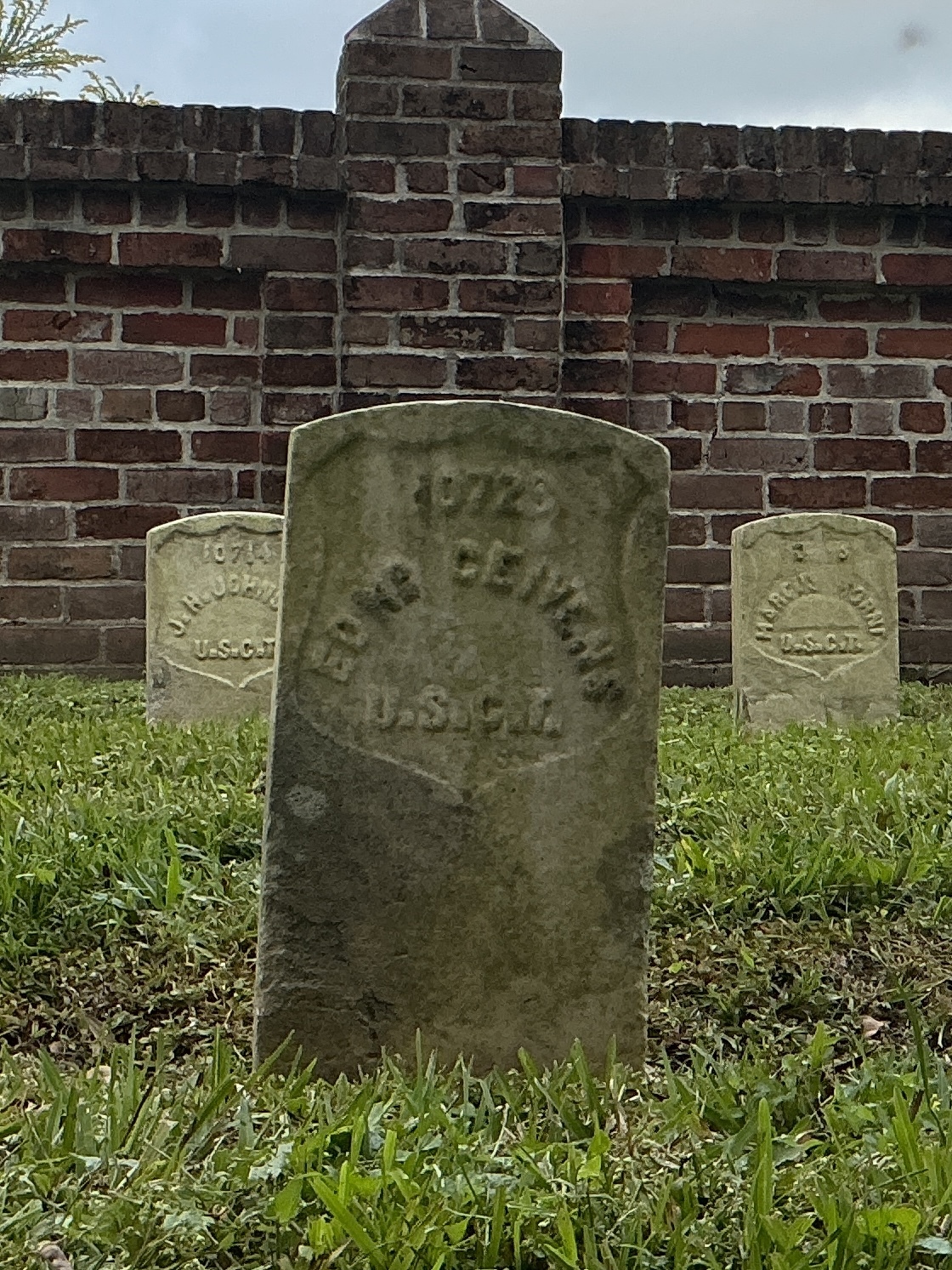 Front of historic upright marble headstone with recessed shield face.