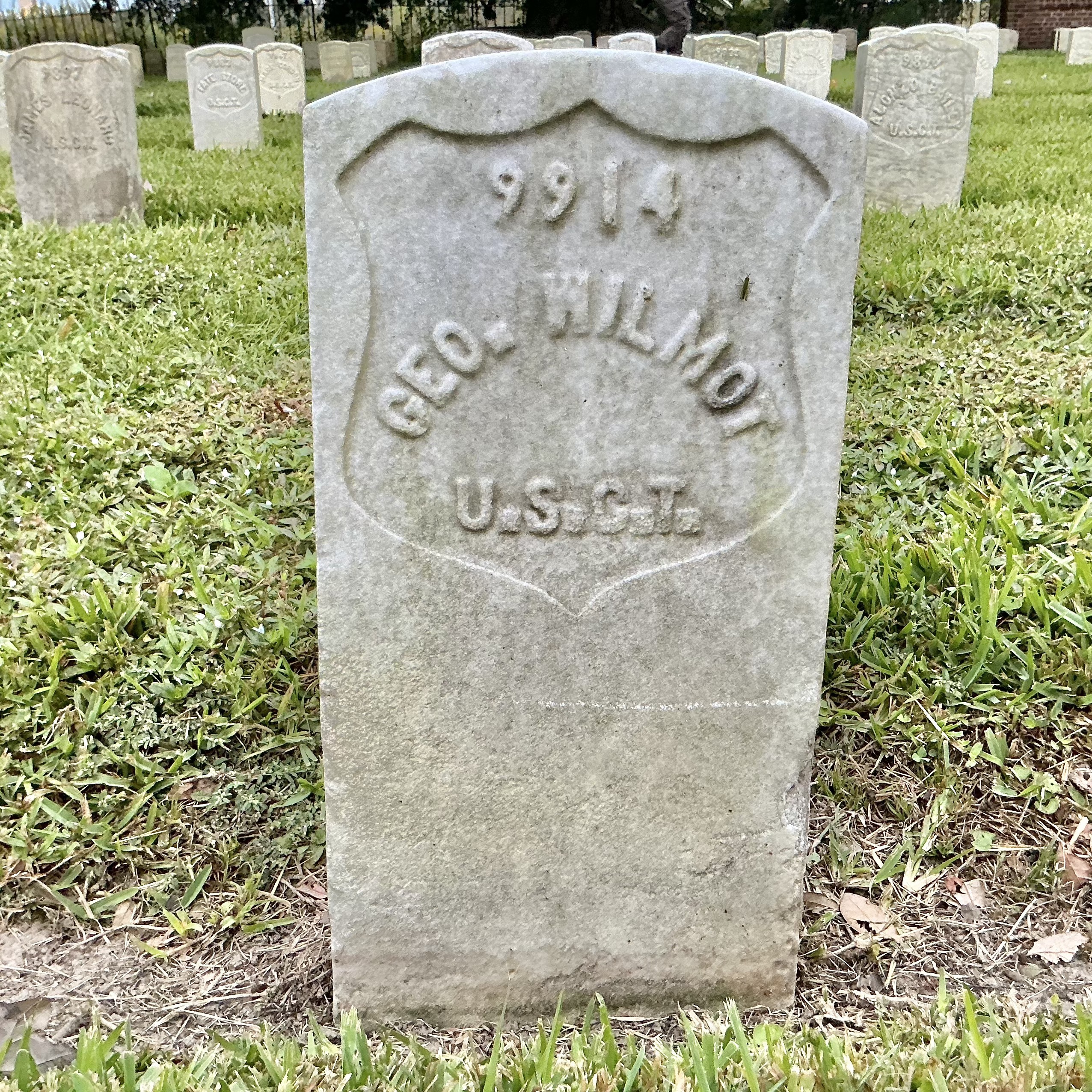 Front of historic upright marble headstone with recessed shield face.