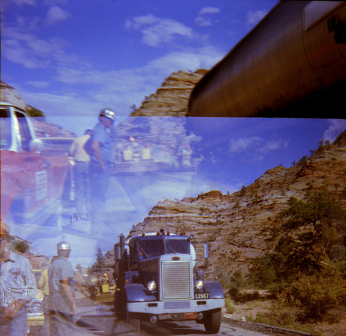 Construction vehicles and construction workers working on chipseals on road.