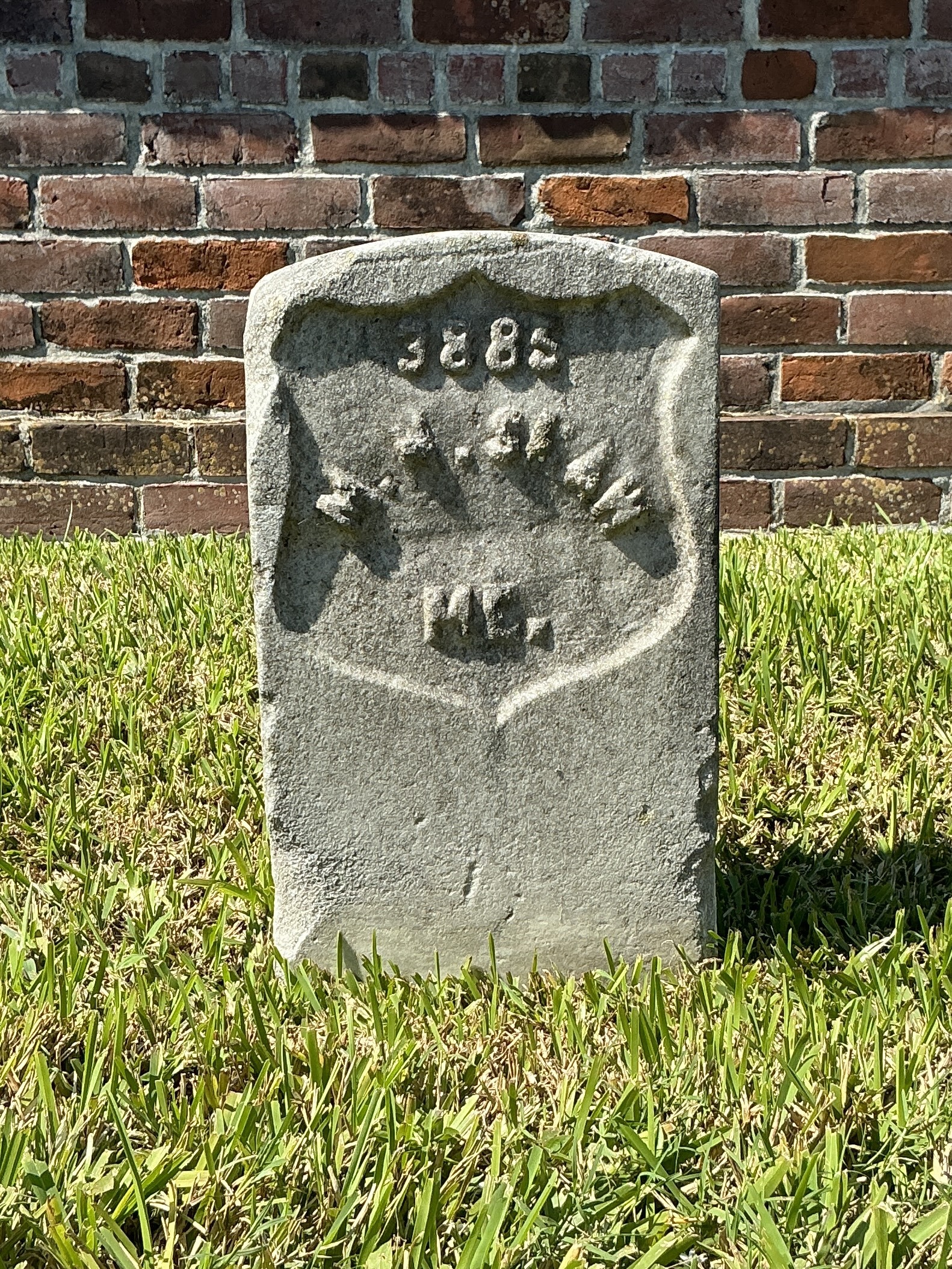 Front of historic upright marble headstone with recessed shield face.