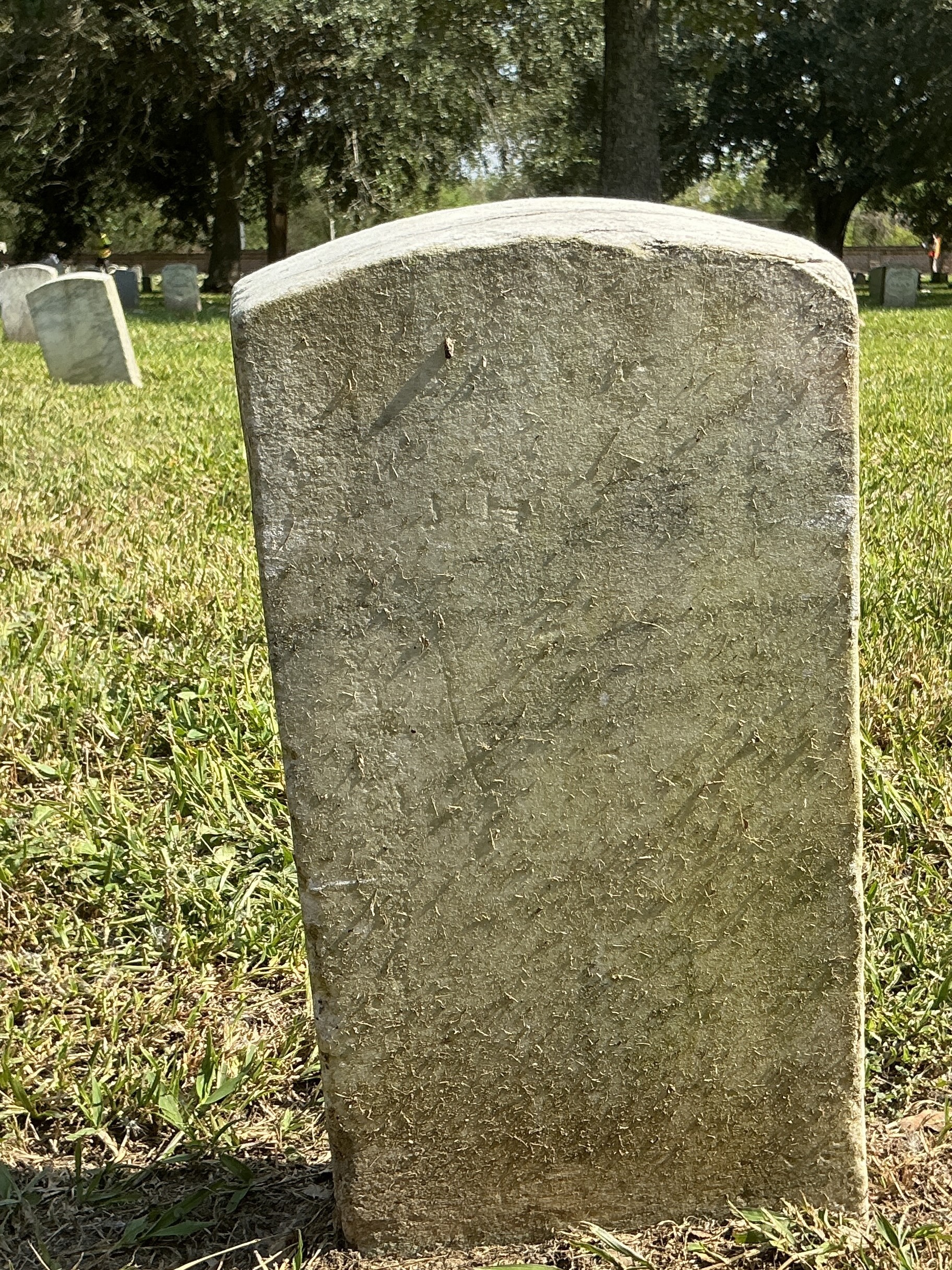 Back of historic upright marble headstone with recessed shield face.