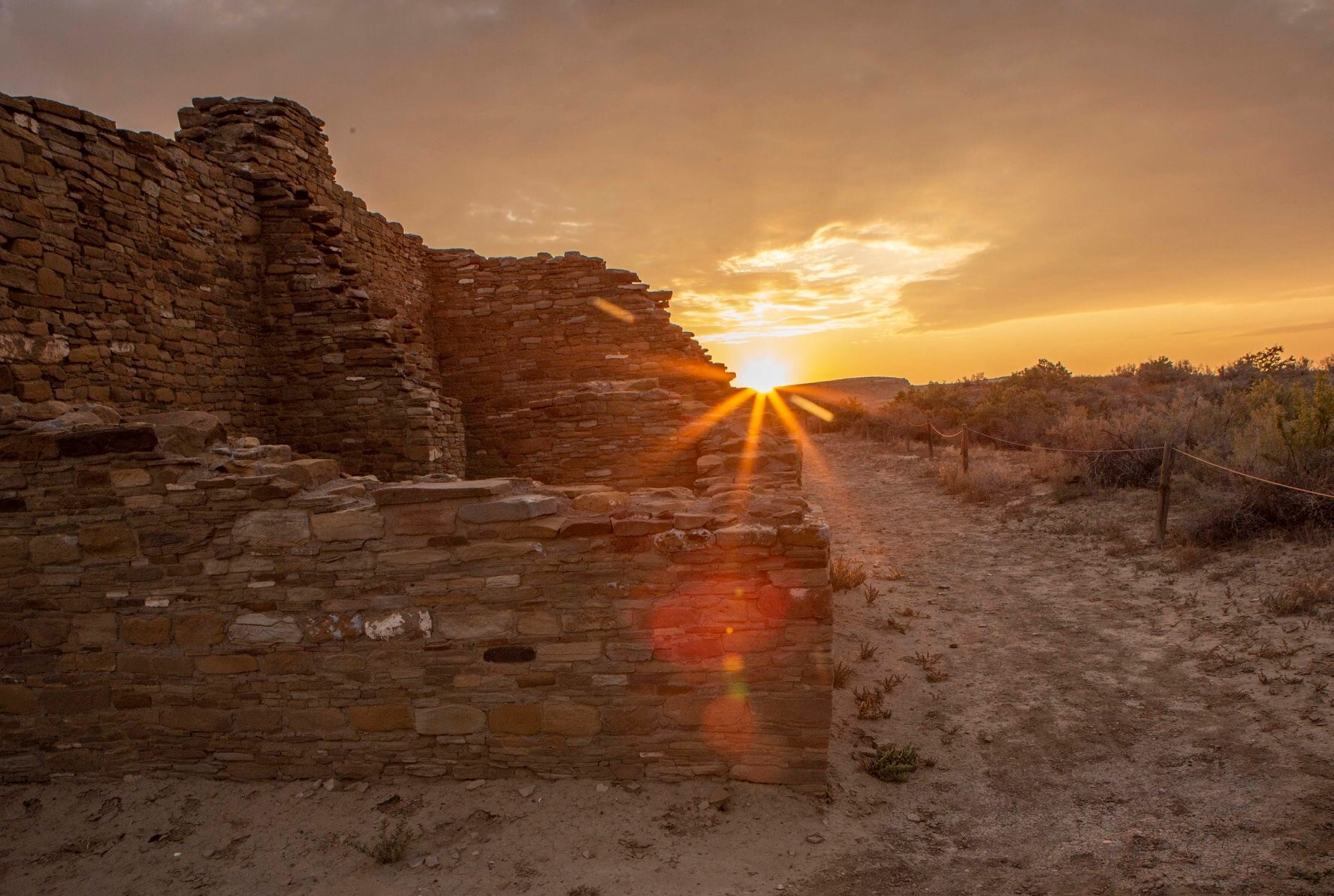 The sunrise coming up over the mesa aligning with a wall at the Pueblo Bonito Great House.