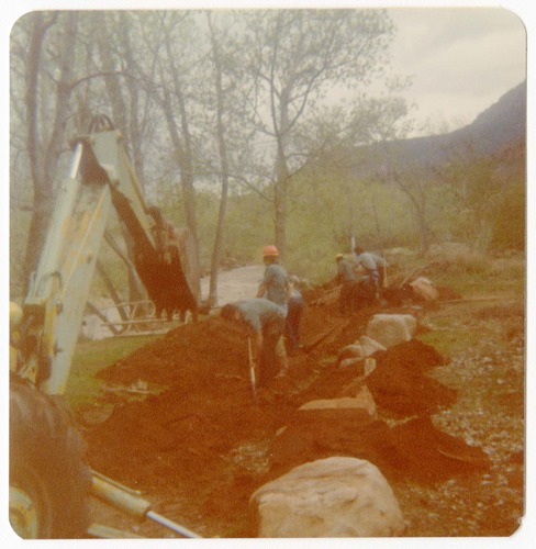 Excavator being used and men working to uncover the irrigation ditch in South Campground.