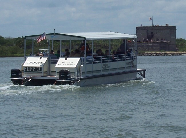 Ferry full of passengers.  Fort in the background