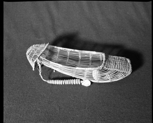 Marie Rozier Collection, Catalog No. 21. Object: Yurok cradle basket model. Dimensions: 16 x 7". Materials: Hazel, beargrass, woodwardia dyed with alder bark, sea urchin and abalone shells. Collection History: Mrs. S. M. Long Collection. Photographed by Michael Dixon in December 1982. Catalogued by Craig Bates and Barbara Beroza. Yosemite Collections, National Park Service.
