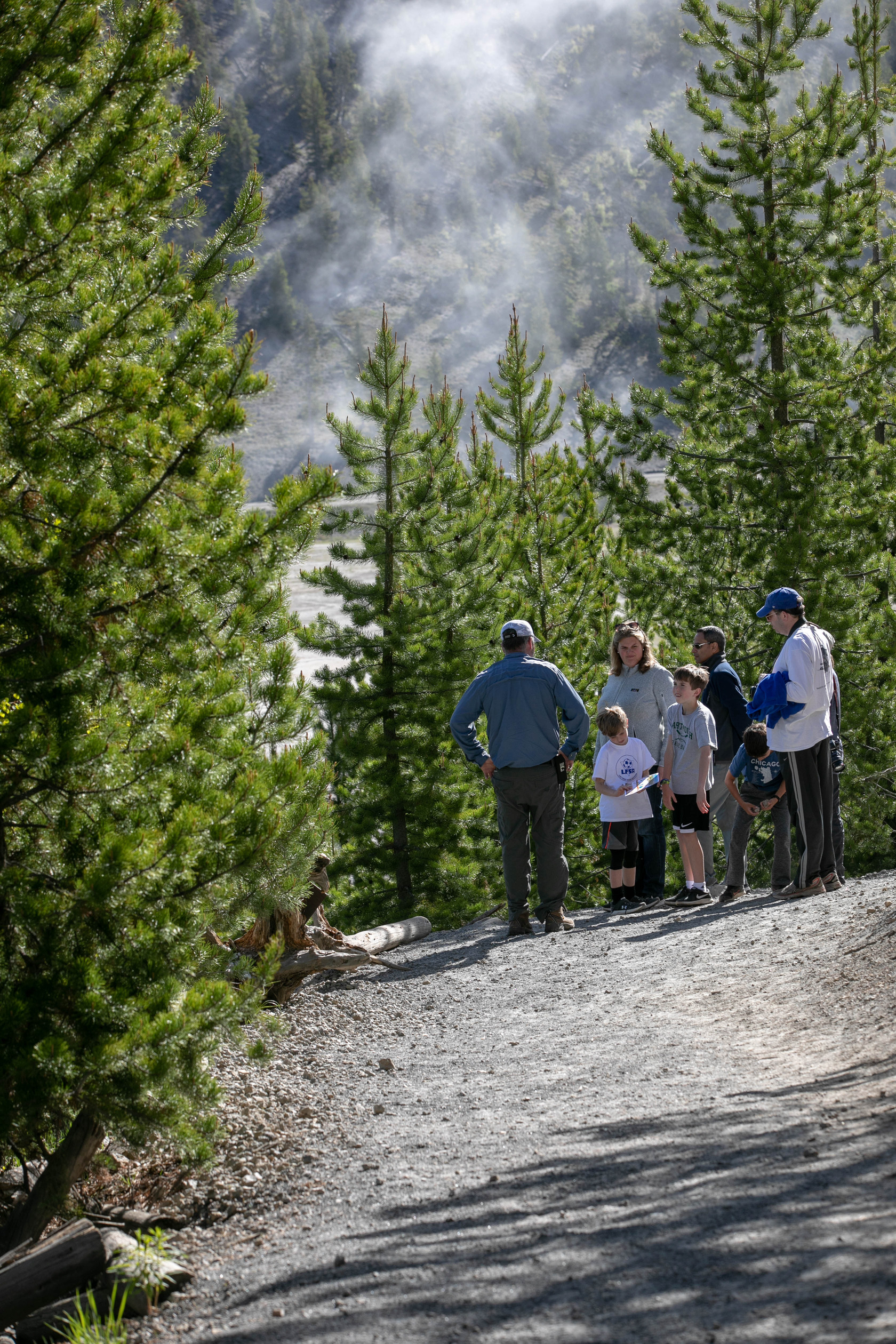 A family stops on the trail up a hill to talk with their guide.