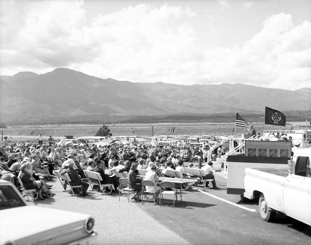 Man addressing visitors from podium at the dedication of Taylor Creek road (Kolob Canyons).