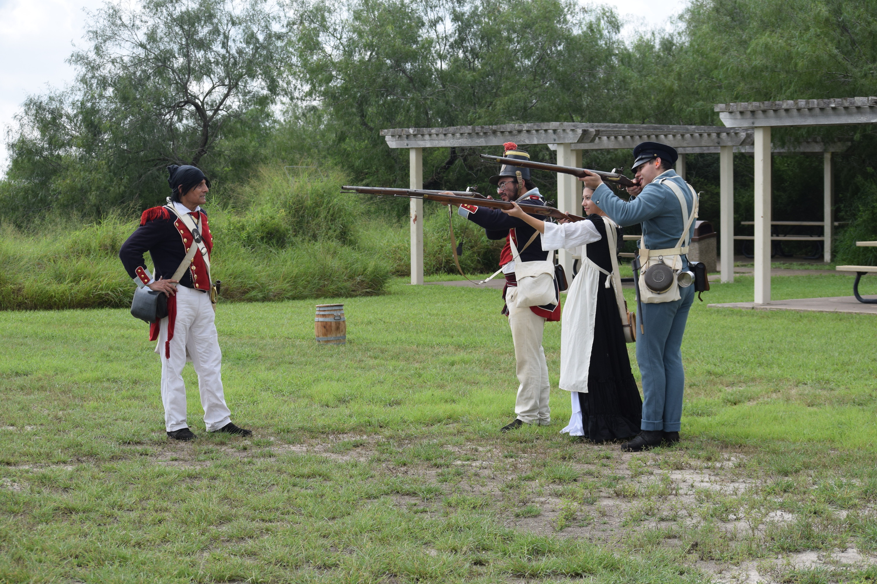 A volunteer leads three other volunteers in a musket firing demonstration.