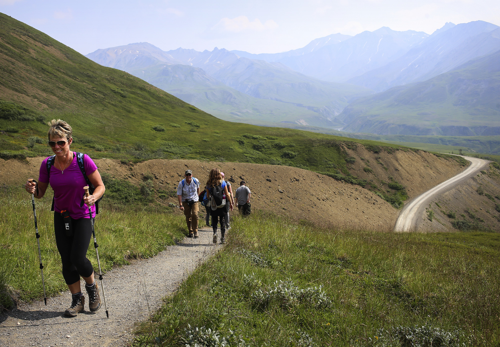 people hiking up a trail on a mountainside