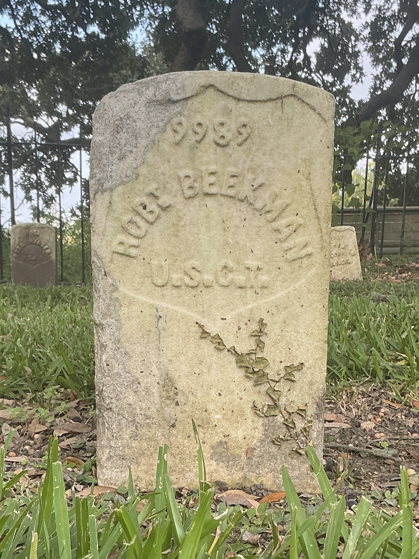 Front of historic upright marble headstone with recessed shield face.