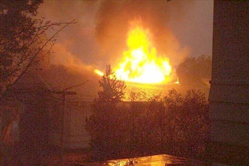 Night photos of a house burning during the Long Mesa fire in Mesa Verde National Park, July-August 2002