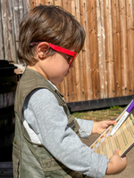 A child looks at a clipboard. 