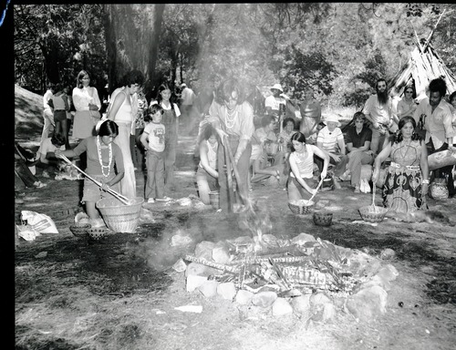 Cooking acorn mush at the Roundhouse dedication, Yosemite Valley. Cooking mush L to R: Lucy Parker, Kim Stevenot, Gael Amend, Bernie Hopper. Craig Bates lifting hot stones from fire.