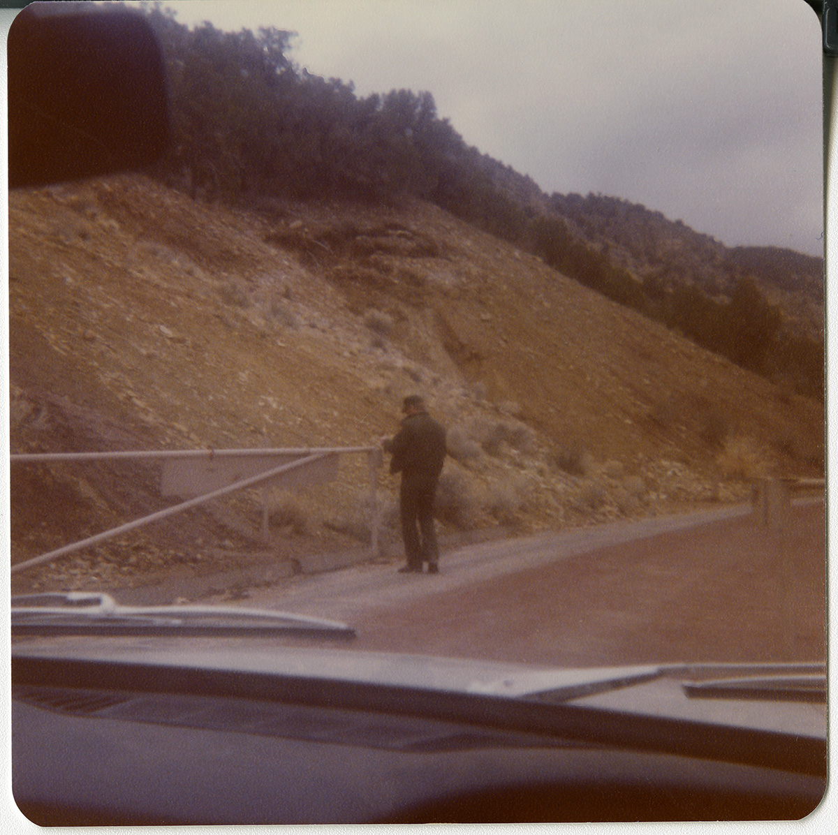 Man opening gate to drive through on Kolob Canyon Road.