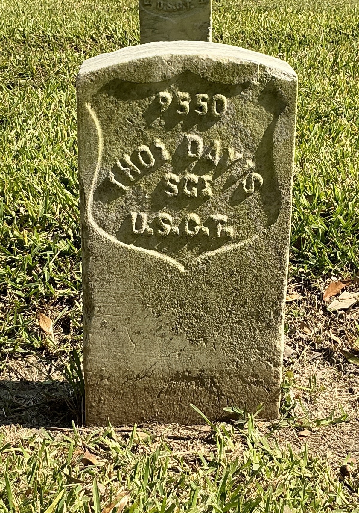 Front of historic upright marble headstone with recessed shield face.