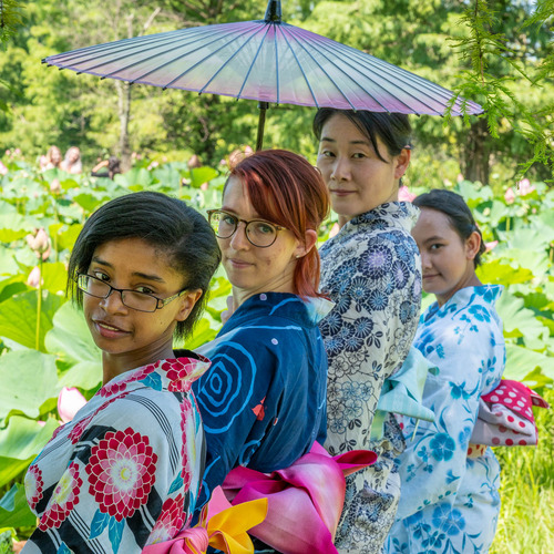 Models from the International Fashion Show pose in front of Lotus flowers.