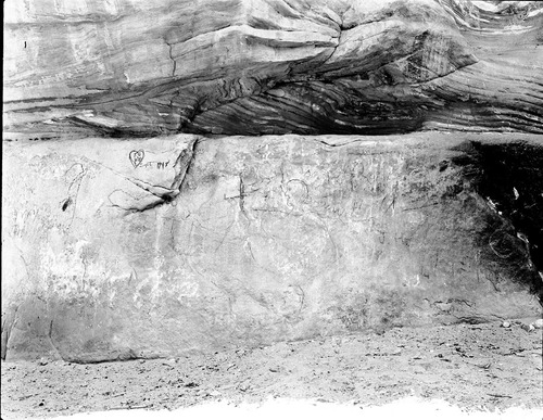 Vandalism at the Grotto. Faces and initials scrawled on rock with charcoal.