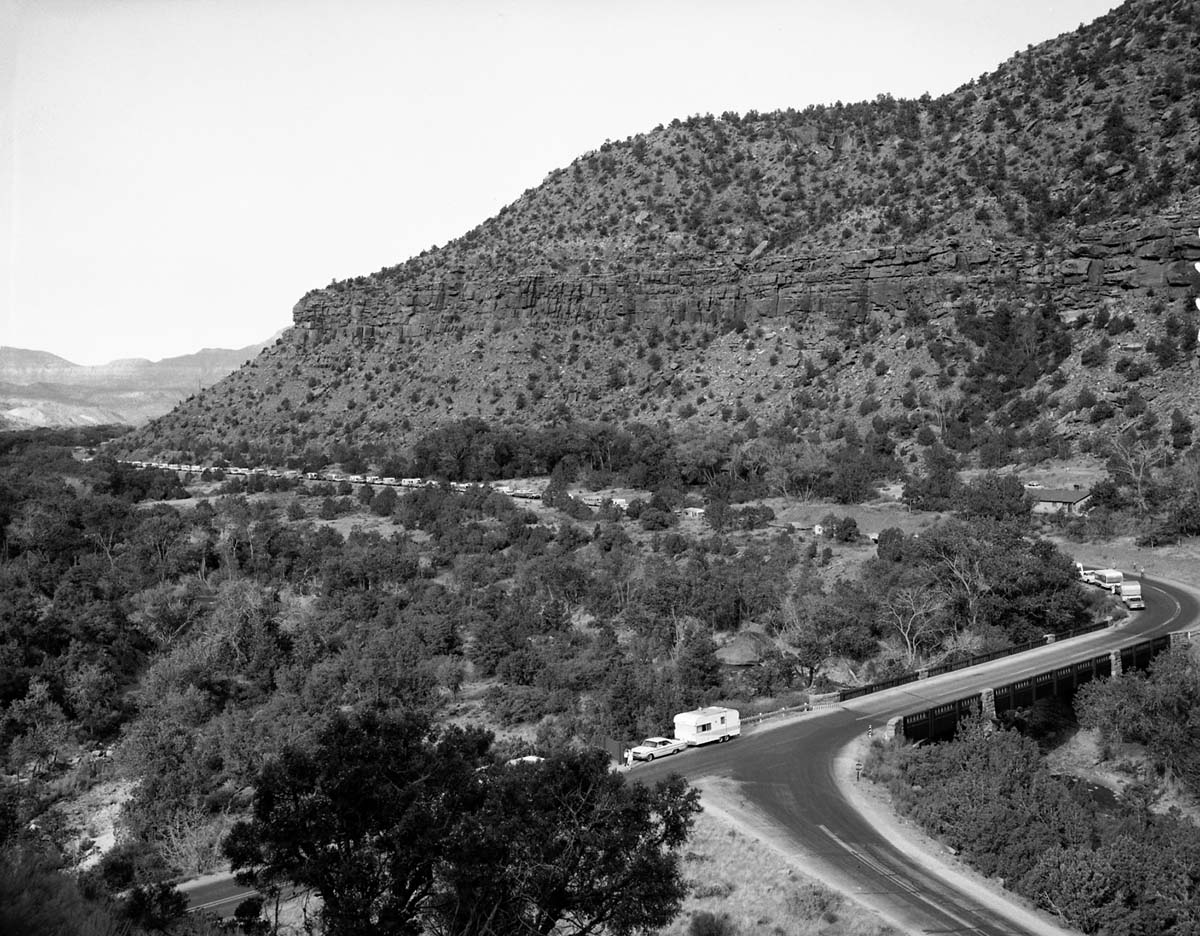 Oak Creek bridge and view of canyon- group of 75 motorhomes in caravan called the Fireballers, preparing to drive through tunnel.
