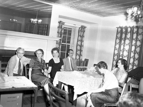 Men and women seated at tables in the ranger dormitory for Mr. and Mrs. Leland Allen's going away party. Allen (at center) accepted position in National Capitol Parks as GS-11 Naturalist.
