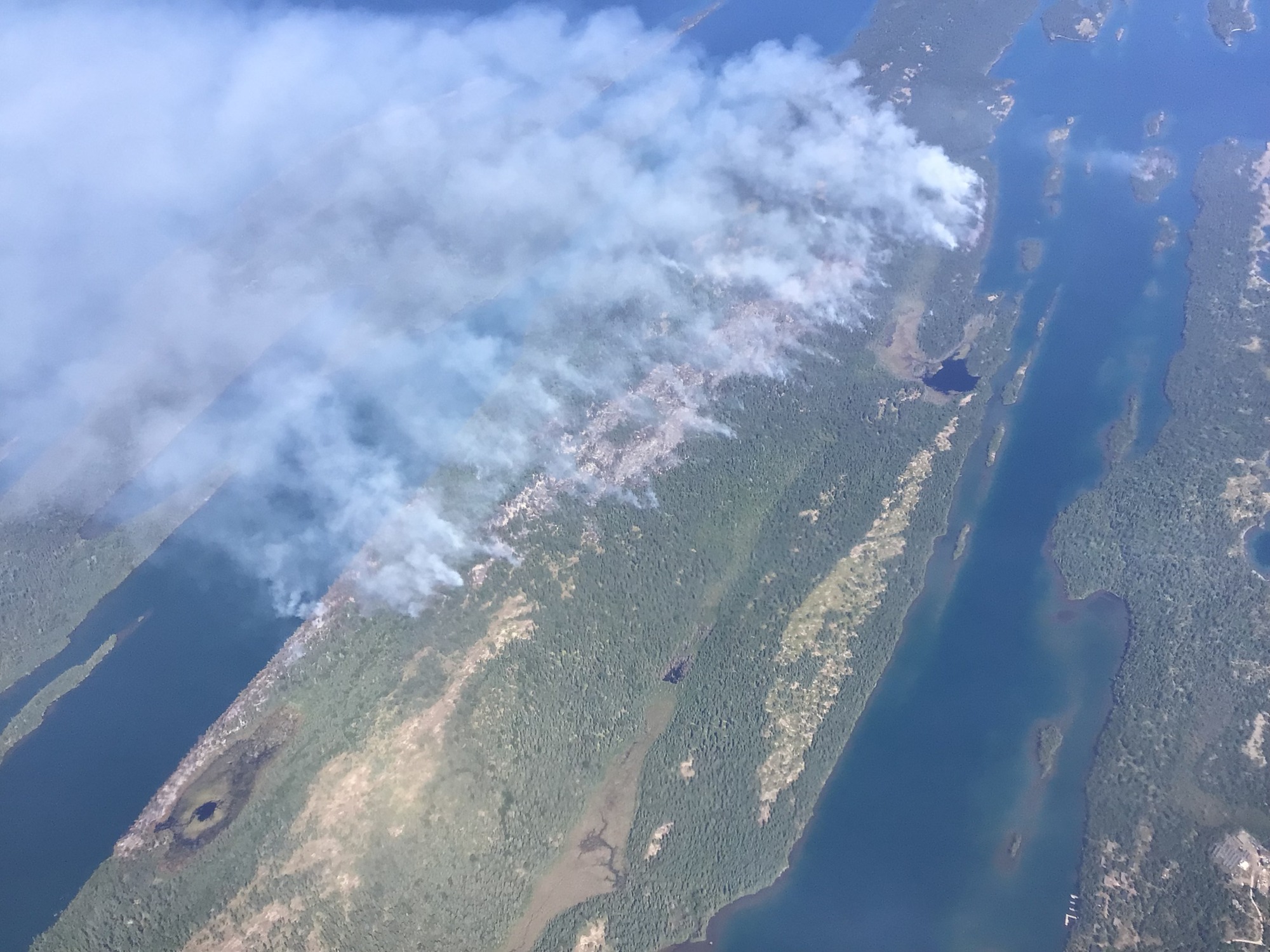 An aerial view of smoke billowing into the sky from a large island.